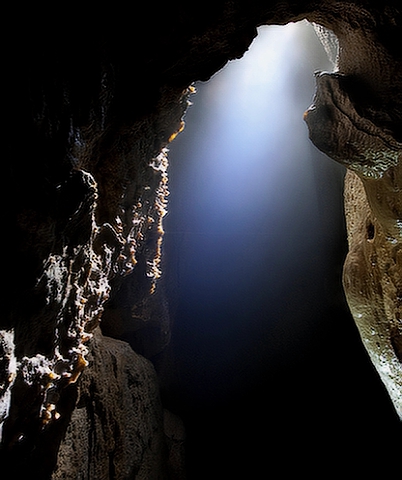 Höhle mit Lichtstrahl. Dunkelretreat und Spiritualität. Saskia John